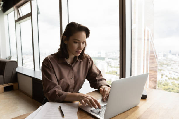 istock Focused remote employee working at laptop from home 1415053247
