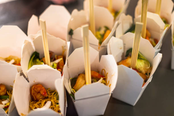 Asian noodles and shrimp with chop sticks take out food on a restaurant counter