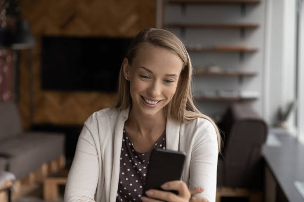 istock Happy young woman using smartphone, reading, texting, smiling 1415053464
