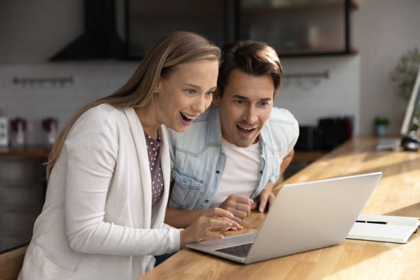 istock Happy surprised millennial couple using laptop, staring at screen 1415053576