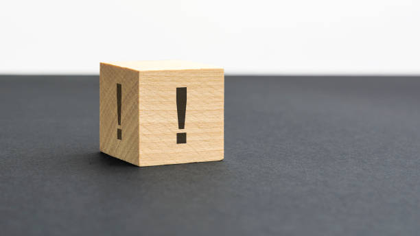 istock exclamation mark sign on a wooden block on a black background with copy space 1415054421