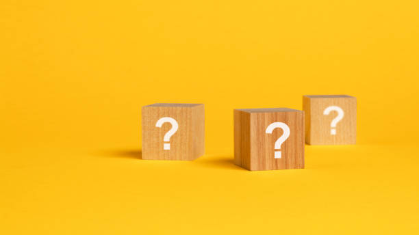 istock three cubes with question mark on wooden background. space for text, yellow background 1415054434