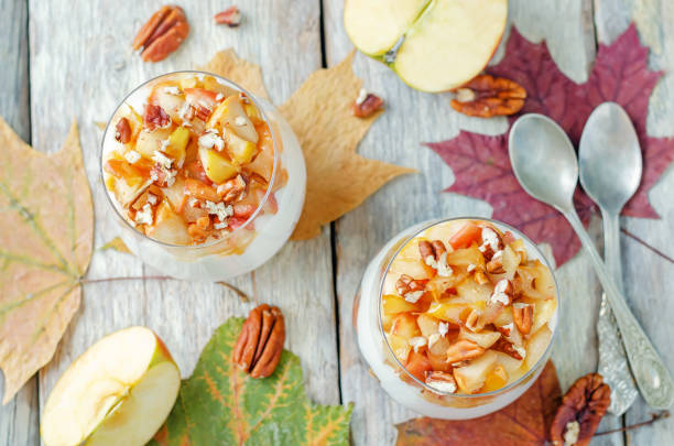 Caramelized apple pecan greek yogurt parfait in a glass Caramelized apple pecan greek yogurt parfait in a glass. toning. selective focus pear dessert stock pictures, royalty-free photos & images