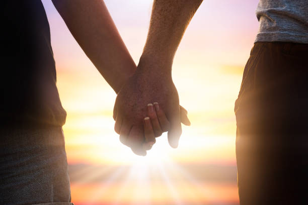 istock couple holding hands on sunset 1415055585