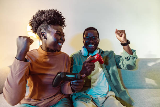 istock Joyful couple celebrating a victory in a video game 1415056459