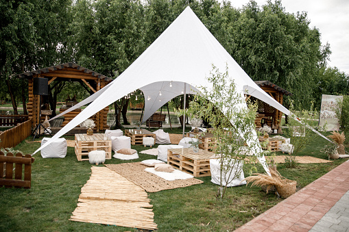 Spacious tent in the garden for a wedding party.