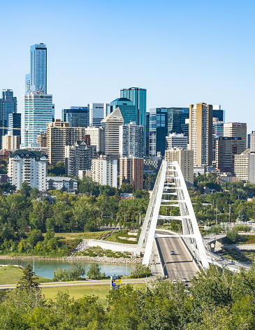 Edmonton, Canada, August 9, 2022: View to the Walterdale Bridge  a through arch bridge across the North Saskatchewan River with city bluish highrises on background and blue sky