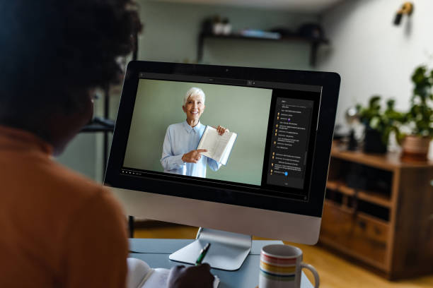 young woman watching online class with teacher - book school desk old imagens e fotografias de stock