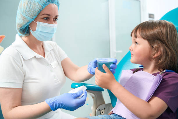 istock Young female patient using mouthrinse after procedure 1415058952