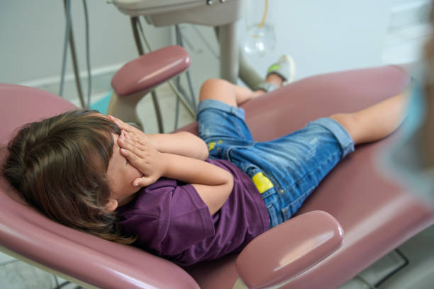 istock Frightened female child lying in dentist office 1415058980