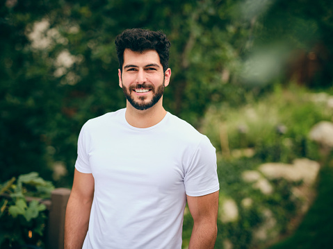 An outdoor portrait of a young adult looking at the camera.