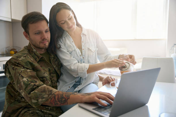 istock Happy young couple at table with laptop and tea 1415063694