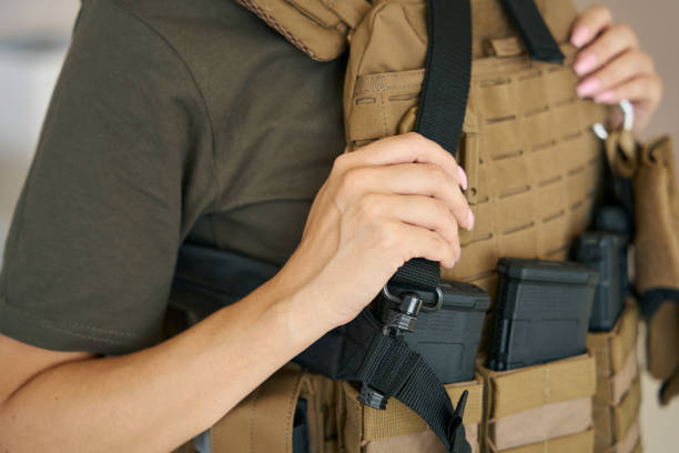 istock Strong female soldier is wearing a protective body armor 1415063781