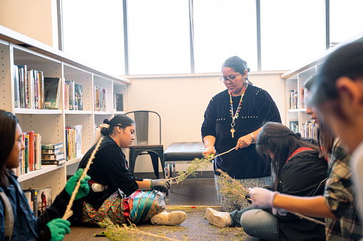 Female Traditional Navajo Teacher Teaching High School Students How to Make Authentic Housekeeping Broom in Keeping With Indigenous Methods