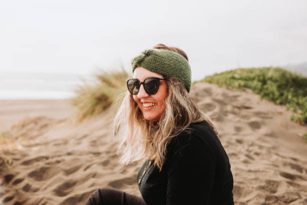 istock Smiling woman sitting on the beach. Overcoming depression. 1415069498