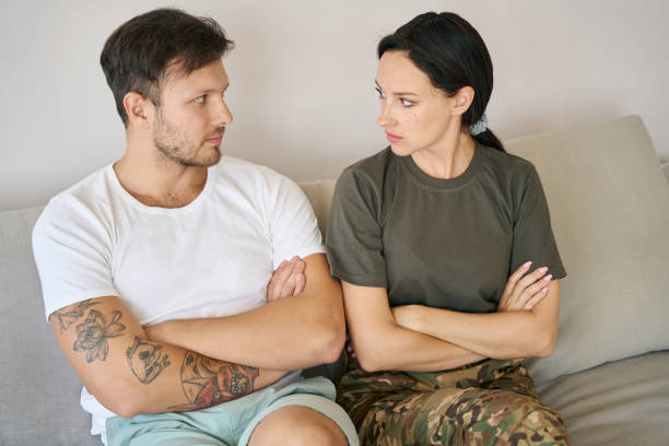 istock Man and woman sitting on sofa in closed poses 1415070720