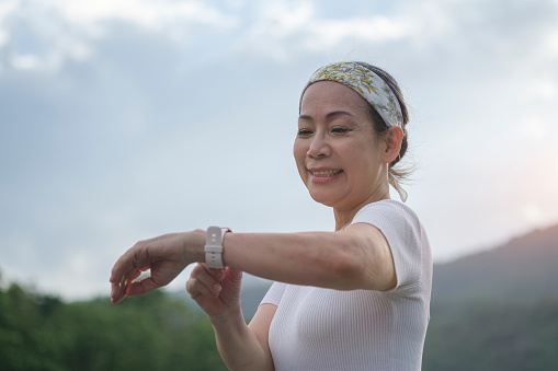 Exercise women use smart watch in nature park.