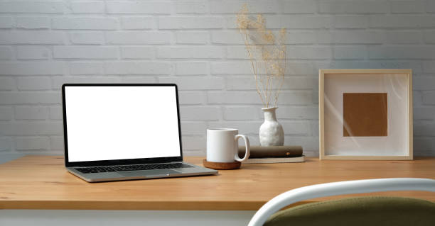 istock Workplace comfortable with computer laptop, coffee cup, notebook, picture frame and flower pot. 1415078087