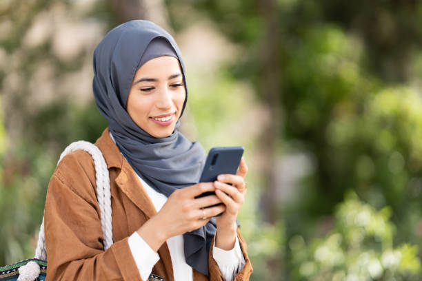 istock Smiling muslim woman using a mobile. Close up 1415078182