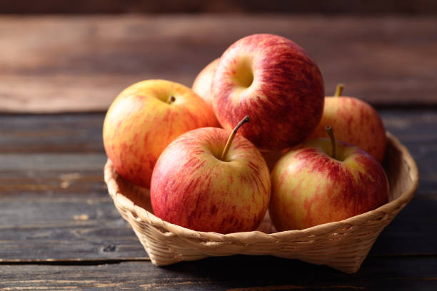 istock Red apple fruit in basket on wooden background 1415081447
