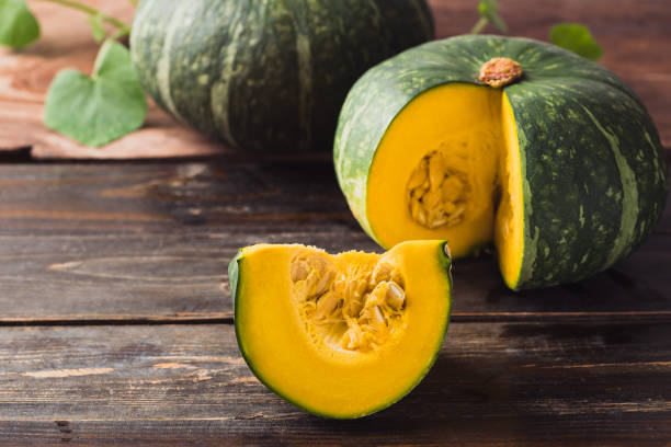 istock Green pumpkin on wooden background 1415082171