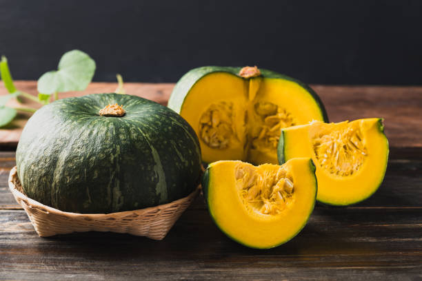 istock Green pumpkin on wooden background 1415082177