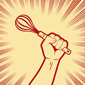 istock One strong fist holding a wire whisk or egg beater 1415082477