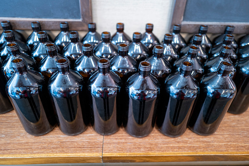 Rows of dark coloured waterbottles outside a cafe.