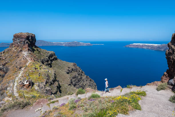 Woman traveler hikes pathways above sea Sea and sky in distance aegean islands stock pictures, royalty-free photos & images