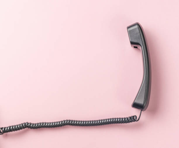 istock Classic handset with a wire on a pink background. 1415091381