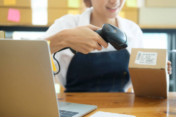 istock Young asian businesswoman use bar code scanner Scan the barcode on the product box. 1415095017