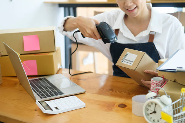 istock Young asian businesswoman use bar code scanner Scan the barcode on the product box. 1415095018