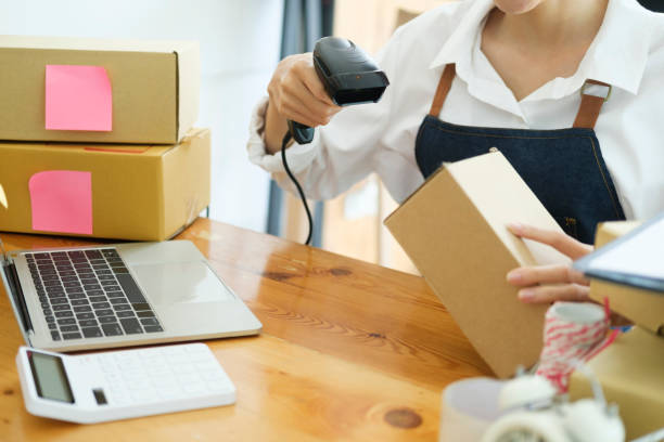 istock Young asian businesswoman use bar code scanner Scan the barcode on the product box. 1415095019