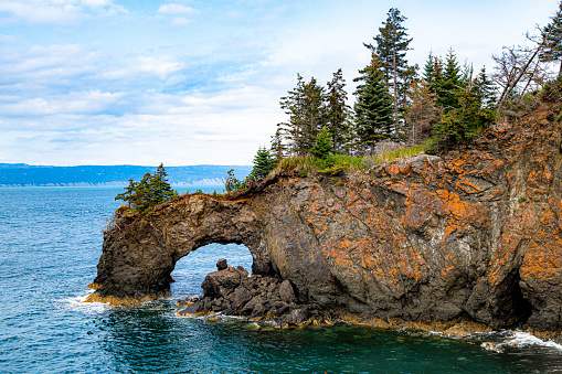 A long exposure of the calm ocean around a rock formation on Cape Breton Island, Nova Scotia.