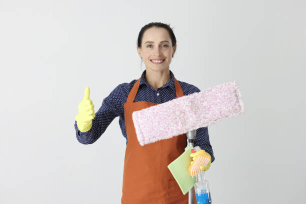 istock Smiling woman with mop holding thumb up 1415098495