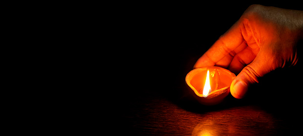 A Diwali lamp lit by hand, Diwali Lamps , Diwali diya lamps lit during diwali celebration