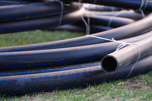 Plastic pipes for underground water supply and sewerage. PVC pipes for underground water supply and sewer pipes on grass. Improving public water supply drainage and wastewater treatment