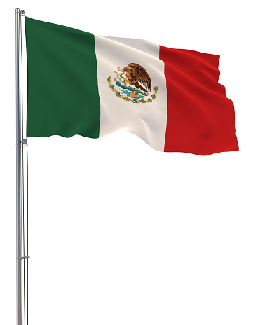 A large Mexican flag (Spanish: Bandera de México), lit with golden pre-sunset light, on a flag pole, with a blue sky, in the Zocalo, Mexico City