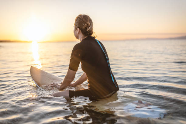 istock Woman sitting on surfboard 1415108109