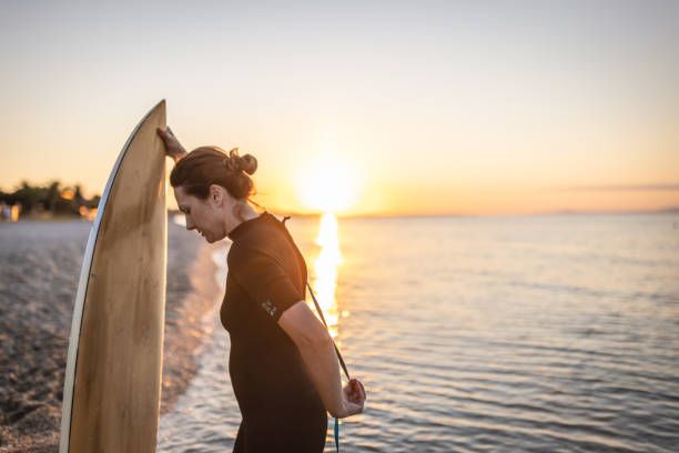 istock Woman at the beach with her surfboard 1415108768