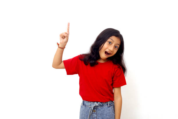 istock Wow and amazed expression of asian little girl while pointing something above on empty space 1415111162