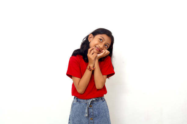 istock Adorable asian little girl standing while thinking something. Isolated on white background 1415111928