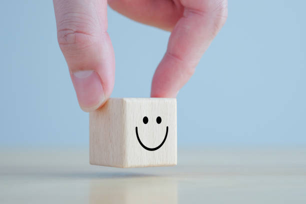 istock Emotion, Mental, Customer service evaluation and satisfaction survey concept. Review, Feedback. Hand holding happy face on wooden blocks. 1415113018