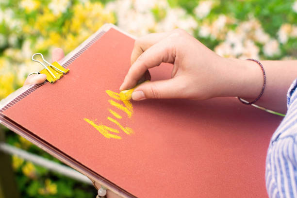 istock Woman drawing landscape and flowers with soft pastels. 1415118917