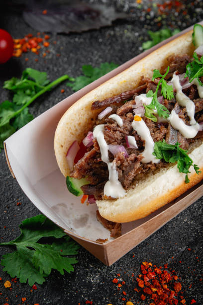 istock Hot dog with vegetables, stuffing with chicken, beef and herbs on a dark stone table. The concept of fast food and delivery restaurants 1415120652