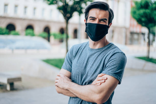 istock Man with protective mask walking outdoors in the city. 1415121811