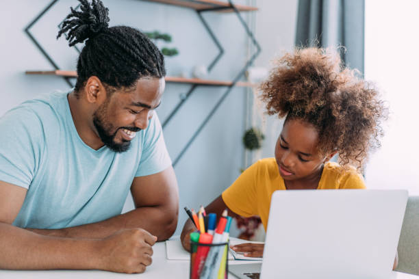 istock Father and daughter studying online at home. 1415121857