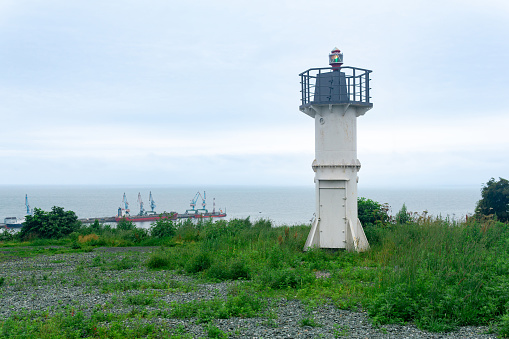 automatic lighthouse with sector light on a high cape above the sea harbor
