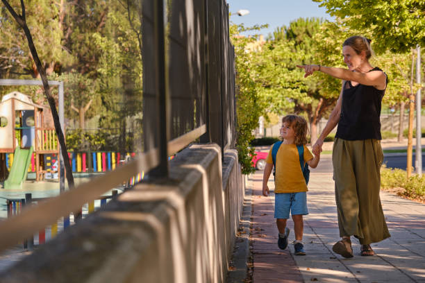 mutter und sohn gehen glücklich zur schule. zurück zur schule - family walking child toddler stock-fotos und bilder