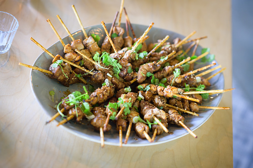 Barbecued Chicken Kebabs with sesame seeds and garnish on wooden sticks tapas canapés
